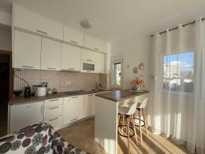 a kitchen with white cabinets and a counter and a window at BlueCoast Apartment in Herceg-Novi