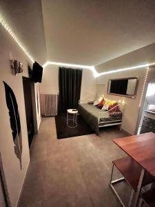 a small living room with a bed and a table at Atypique, calme & cosy, proche de Paris in Bonneuil-sur-Marne