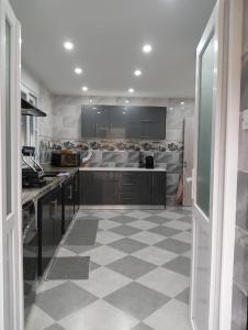 a large kitchen with a checkered floor in a room at Maison de repo in Mostaganem