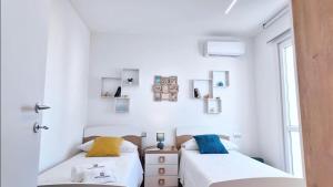 two beds in a small room with white walls at Pietrazzurra in Squinzano +38 photos