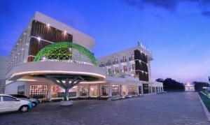 a hotel with a parking lot in front of a building at D'MAX Hotel & Convention Lombok in Praya