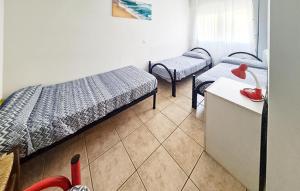 a room with two beds and a table with a desk at Milla 2 in Rosolina Mare