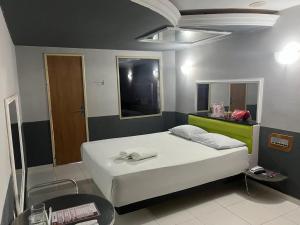 a bedroom with a white bed in a room at Eros Motel in Natal +5 photos