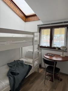 a bedroom with bunk beds and a desk and a table at Residence Principe di Saronno in Saronno