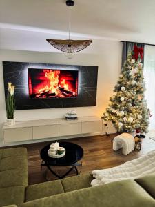 a living room with a christmas tree and a fireplace at Aurora Noir Retreat in Banja Luka
