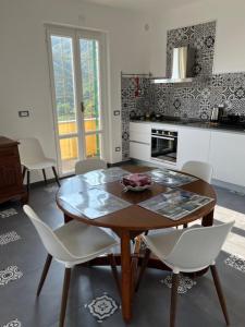 una cucina con un tavolo di legno e sedie bianche di Photo&Communication a Bonassola