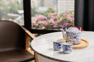 a blue and white tea pot and two cups on a table at The Federal Kuala Lumpur in Kuala Lumpur