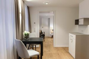 Maximilian Apartments Lindau في لينداو: مطبخ وغرفة طعام مع طاولة وكراسي +45 صورة