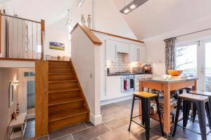 een keuken met een trap en een tafel met krukken bij The Deck House - St Monans in Saint Monance