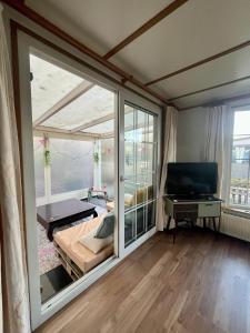 Vakantiepark Klein Vink - 25 في بوكهاوْسِن: غرفة نوم مع نافذة زجاجية كبيرة وسرير +8 صور