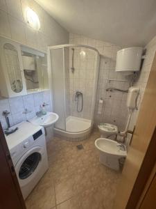 a bathroom with a toilet sink and a washing machine at Villa Sale Buna in Mostar
