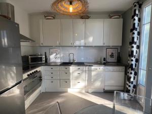 a kitchen with white cabinets and a glass table at Golden hours luxury and panoramic view in Nice +20 photos