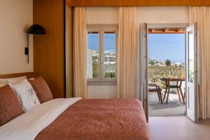 a hotel room with a bed and a balcony at Safrani Suites in Fira