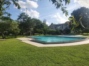 a swimming pool in a park with a building at Tabbowa Lake Resort in Puttalam