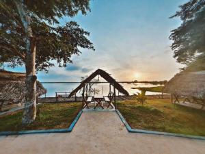 uma casa com mesa de piquenique e vista para a água em Tabbowa Lake Resort em Nikawatawana