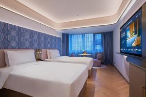 Ένα ή περισσότερα κρεβάτια σε δωμάτιο στο Beijing Guomao Jianguomen Manxin Hotel