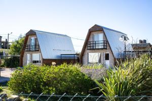 two houses with metal roofs in a yard at Brisas del Ceferino in Sierra de la Ventana