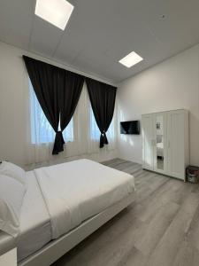 a bedroom with a large white bed with black curtains at Viva Residence in Calderara di Reno