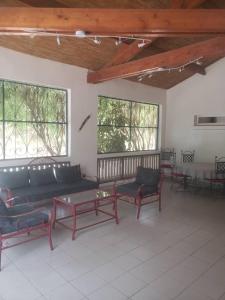 Le Ganalé في Warang: غرفة معيشة مع كنب وطاولات ونوافذ