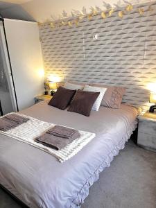 a bedroom with a large white bed with towels on it at Atypique, calme & cosy, proche de Paris in Bonneuil-sur-Marne +28 photos