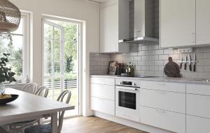 a kitchen with white cabinets and a table and a window at 2 Bedroom Amazing Home In Färjestaden in Algutsrum
