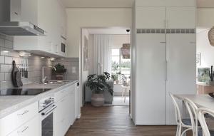 a kitchen with white cabinets and a sink and a table at 2 Bedroom Amazing Home In Färjestaden in Algutsrum
