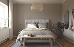 a bedroom with a bed and a table with flowers on it at 2 Bedroom Amazing Home In Färjestaden in Algutsrum