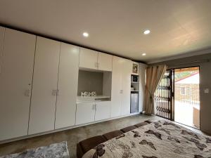 a living room with white cabinets and a kitchen at Lavender Lane in Denysville