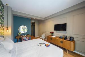 a hotel room with a bed and a flat screen tv at The Oscar Olympic Hotel in Thessaloniki