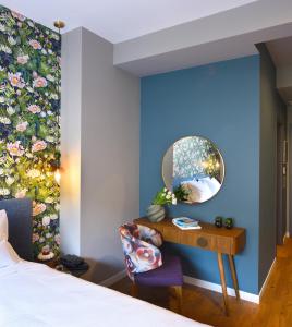 una camera da letto con un letto e una scrivania con uno specchio di The Oscar Olympic Hotel a Salonicco Altre 44 foto