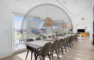 Un comedor largo con una mesa larga y sillas. en Amazing Home In Idestrup With Sauna, en Stovby