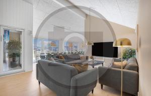 una sala de estar con sofás y sillas en un edificio en Amazing Home In Idestrup With Sauna, en Stovby