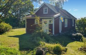 Una pequeña casa con una bandera en un patio. en 2 Bedroom Amazing Home In Fagerhult, en Bockasjögle 6 fotos más