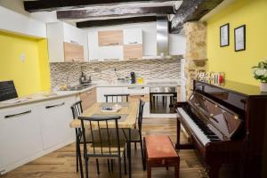 a kitchen with a wooden table and a piano at Casa vacanze Harmonie in Olevano Romano