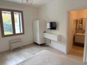 Una habitación blanca con un refrigerador y un televisor. en Residence B&B il Connubio, en Impruneta