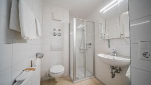 un bagno bianco con un water e un lavandino di Comfort Boardinghouse a Stoccarda Altre 21 foto