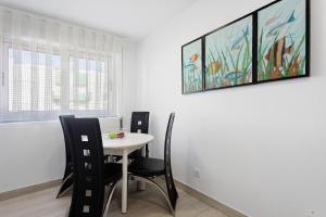 een eetkamer met een tafel en stoelen en een schilderij bij Natalina T1 in Pederneira +14 foto's