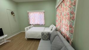 una camera da letto con un letto, un divano e una finestra di Deliana s Homestay a Dithur