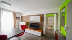 un soggiorno con tavolo da pranzo e televisione di Comfort Boardinghouse a Stoccarda