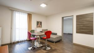 una stanza con un tavolo, sedie e un divano di Comfort Boardinghouse a Stoccarda