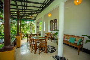 a dining room with a table and some chairs at Sleeper Wood Villa in Unawatuna
