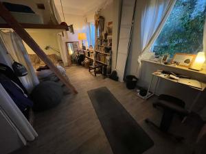a living room with a bed and a desk and a window at Robinson guesthouse & massages in Marseille +20 photos