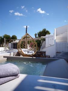 a pool with a swing and a swimming pool at Corina Studios-Apartments in Naousa