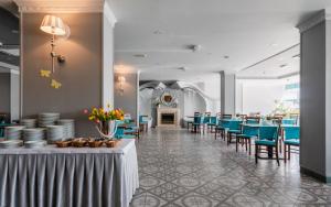 ein Esszimmer mit Tischen und Stühlen und einem Kamin in der Unterkunft Hotel Wodnik Twój Hotel z widokiem na morze in Ustronie Morskie