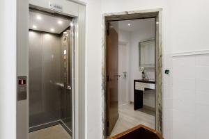 een badkamer met een inloopdouche en een spiegel bij Natalina T1 in Pederneira