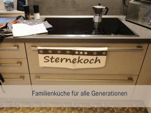 een aanrecht met een gootsteen met een bordje erop bij Ferienhaus Däschinger Das Zweiradparadies in Mastershausen