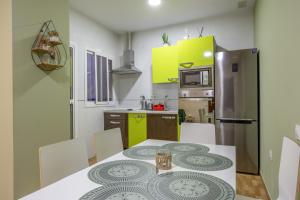 cocina con mesa y cocina de color amarillo en La Bella Escondida, en Cádiz