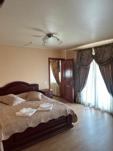 una camera da letto con un letto con due asciugamani sopra di Sunrise Hotel ad Adjud