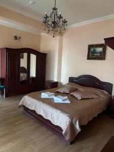 una camera da letto con un letto grande con un lampadario di Sunrise Hotel ad Adjud