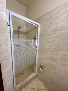 una doccia con una porta in vetro in un bagno di Sunrise Hotel ad Adjud